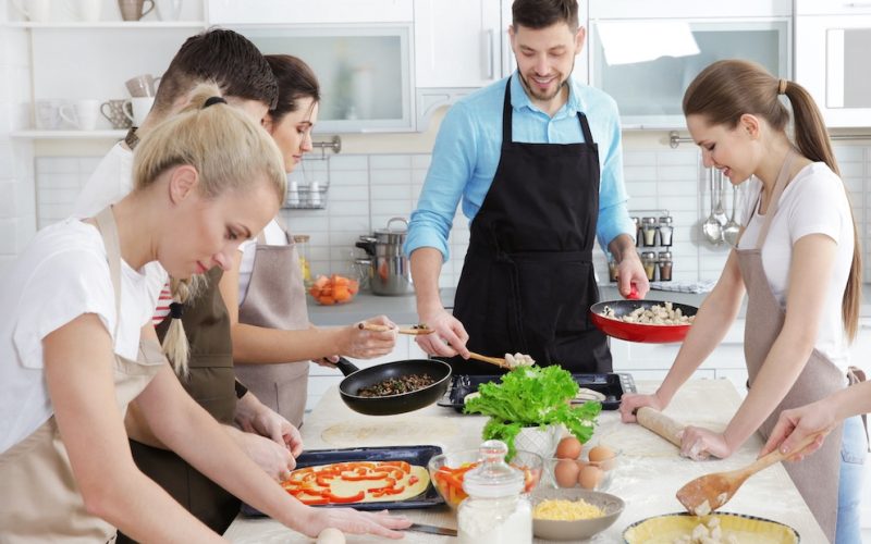 Male chef and group of people at cooking classes